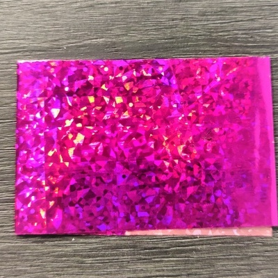 Cartão holográfico rosa sobre mesa de madeira