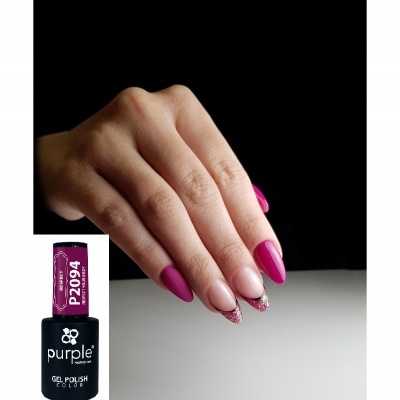 Mãos com unhas pintadas em rosa fúcsia e detalhes dourados ao lado de frasco de verniz gel