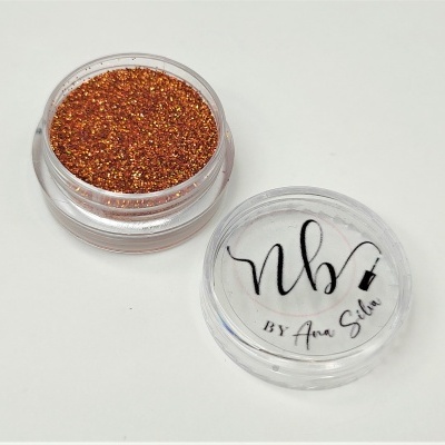 Pó brilhante laranja metálico em embalagem pequena redonda transparente com tampa texto 'nb BY Ana Silva'