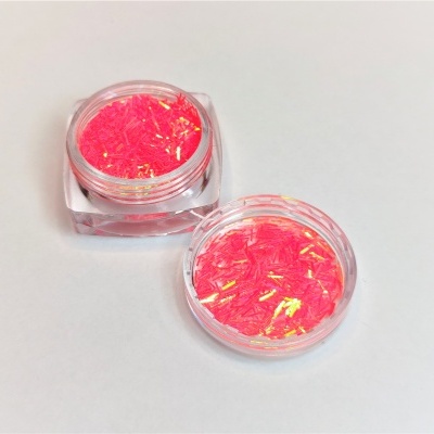 Frascos pequenos contendo glitter cor de rosa com reflexos dourados