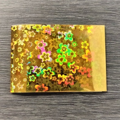 Papel dourado holográfico com padrão de flores coloridas