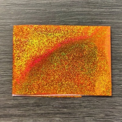 Cartão holográfico laranja sobre madeira escura