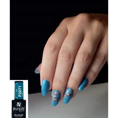 Unha feminina com verniz azul turquesa e decoração floral com pedras.