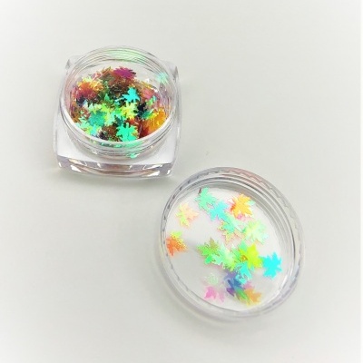 Frascos transparentes com confetes holográficos de folhas coloridas