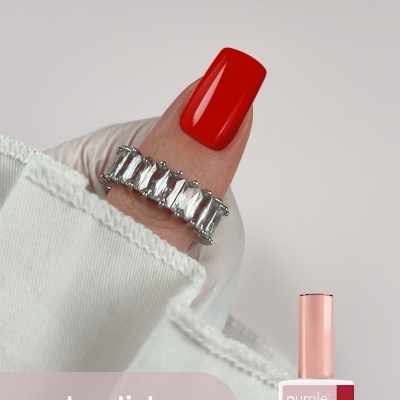 Unha com verniz gel vermelho brilhante e anel prateado, com texto e frasco de gel polish