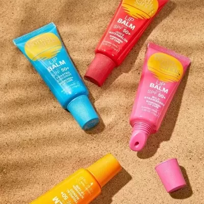 Tubos coloridos de protetor labial Bondi Sands na areia