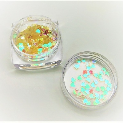 Caixas transparentes com partículas brilhantes em forma de corações