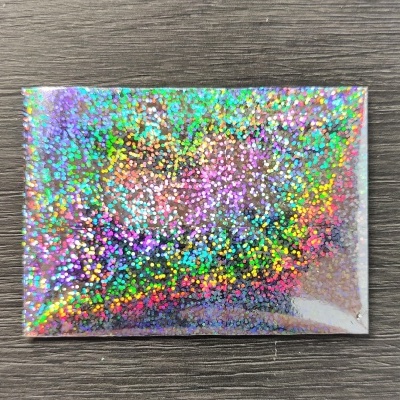 Cartão holográfico colorido sobre superfície de madeira escura