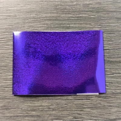 Papel holográfico roxo brilhante sobre superfície de madeira clara