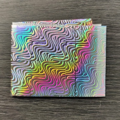 Cartão colorido iridescente com padrão ondulado sobre madeira escura