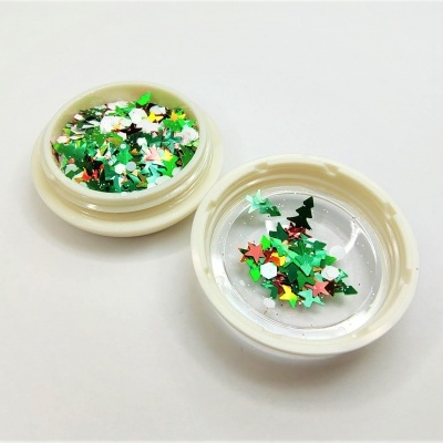 Dois recipientes plásticos com confetis coloridos em forma de estrelas e árvores de Natal