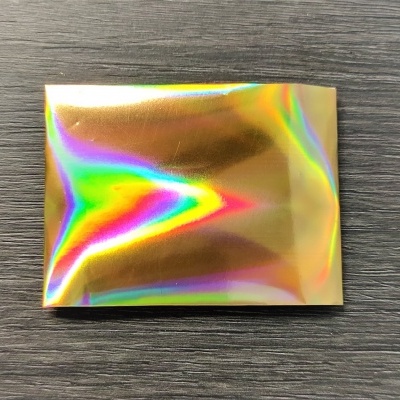 Pacote metálico iridescente sobre superfície de madeira escura