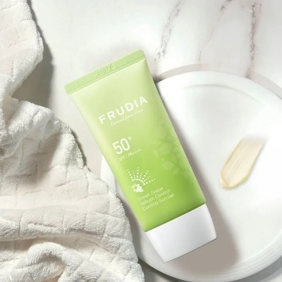 Tubo verde de protetor solar Frudia 50+ SPF com pano branco e prato