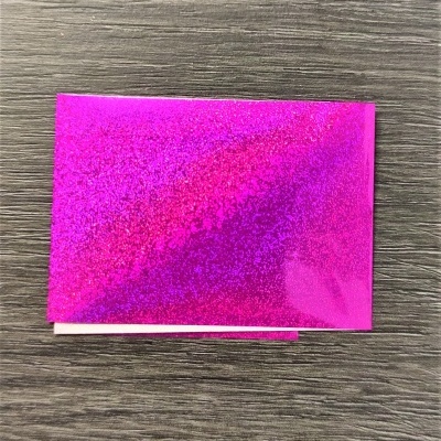 Pedaço de papel rosa fluorescente brilhante sobre superfície de madeira escura