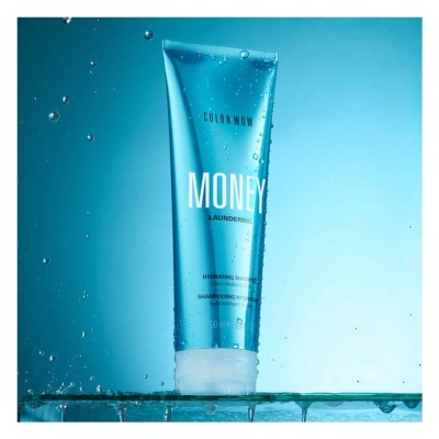 frasco azul de shampoo Color Wow com texto MONEY LAUNDERING e gotas de água