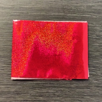 Pacote pequeno com glitter vermelho em fundo de madeira escura