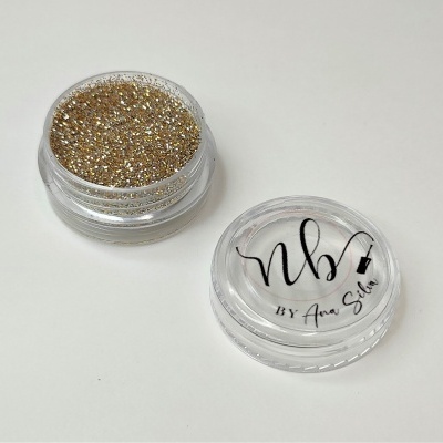 Pote transparente com glitter dourado e tampa com texto NB By Ana Silva