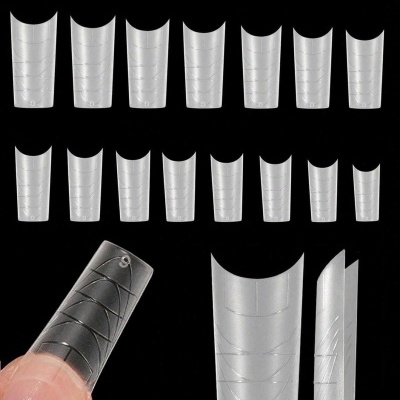 Extensões de unhas artificiais transparentes com padrões geométricos em fundo preto