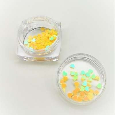 Frascos transparentes com confetes de coração amarelos e verdes