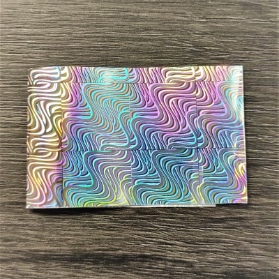 Caixa retangular com padrão ondulado colorido sobre superfície de madeira cinza