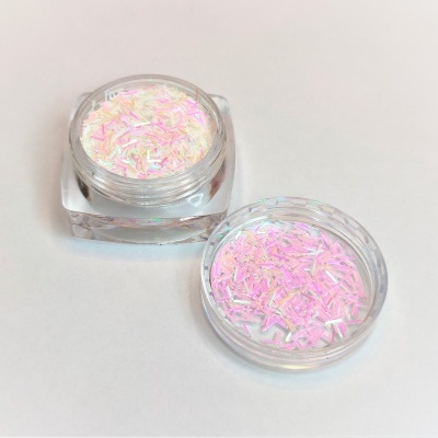 Frasco de plástico transparente com glitter branco com reflexos rosa e lilás sobre superfície branca
