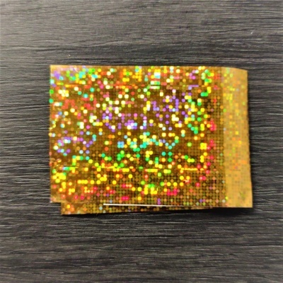 Pacote holográfico dourado sobre superfície escura