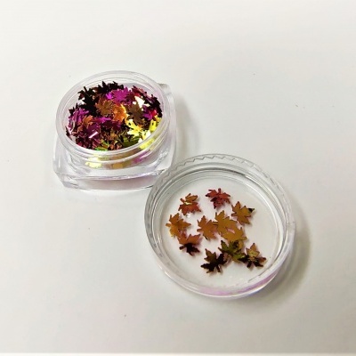 Confetes metálicos em forma de folhas de bordo dentro de recipientes transparentes