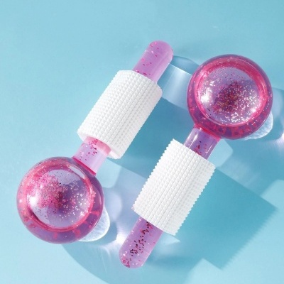 Dois massajadores rosas com purpurina e pega branca sobre fundo azul