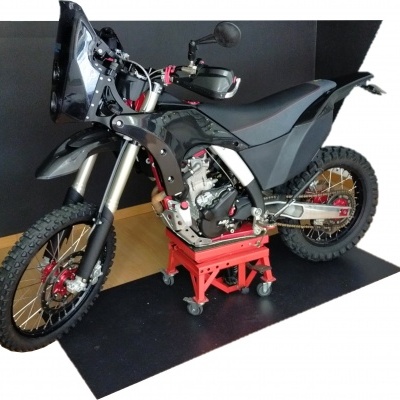 Motociclo todo-o-terreno preto num suporte vermelho