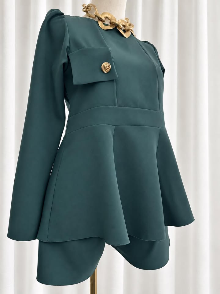 Conjunto Nancy Blusa verde-escura com botão dourado e colar dourado em manequim.