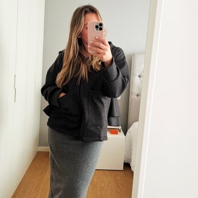 Mulher a tirar selfie com casaco preto e saia cinza