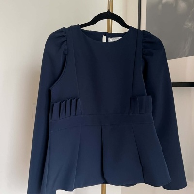 Blusa azul escura de manga comprida com pregas na cintura e corte levemente rodado
