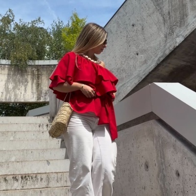 Mulher com roupa casual colorida num cenário urbano com escadas de cimento.