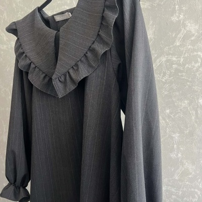 Vestido ou blusa cinza escuro com riscas finas, gola com folhos e mangas compridas em cabide.