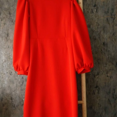 Vestido vermelho comprido com mangas bufantes pendurado