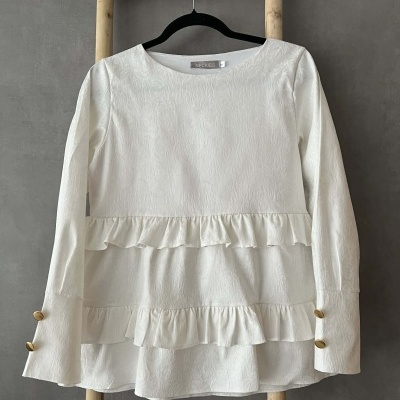 Blusa branca texturizada com folhos e botões dourados