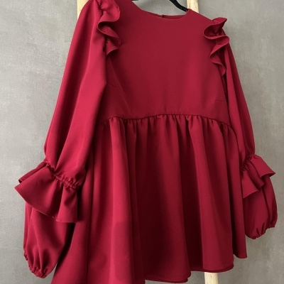 Blusa vermelha com folhos e mangas bufantes pendurada em cabide