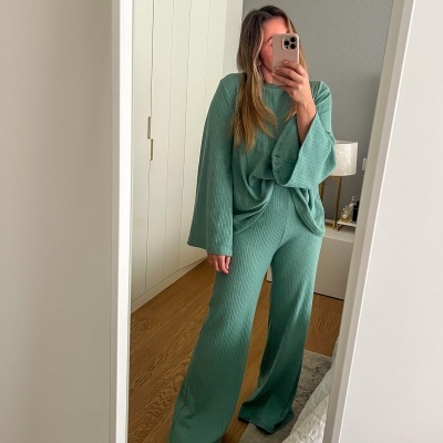 Conjunto de duas peças em tecido verde com textura canelada, camisola de mangas largas e calças largas