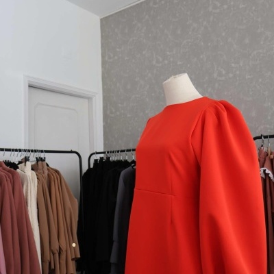 Vestido vermelho com mangas bufantes em manequim numa loja de roupas