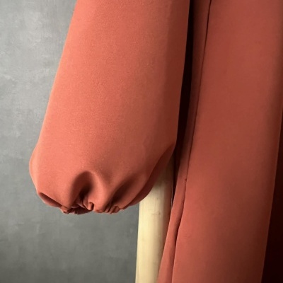 Manga longa terracota com punho elástico em fundo cinzento