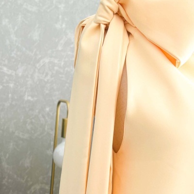 Vestido amarelo claro com nó na alça e tecido liso em manequim