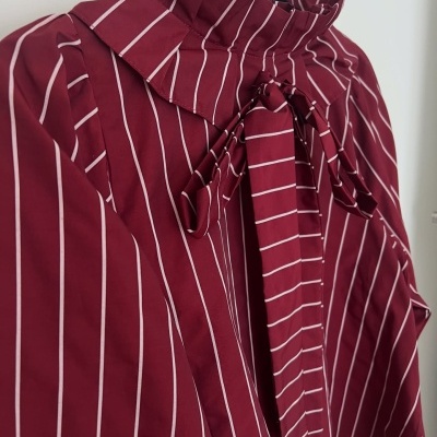 Blusa bordeaux às riscas brancas com gola e laço pendurada