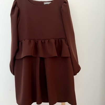 Vestido castanho escuro com mangas compridas pendurado em cabide