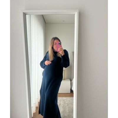 Mulher vestida com vestido azul escuro comprido a tirar uma selfie em espelho