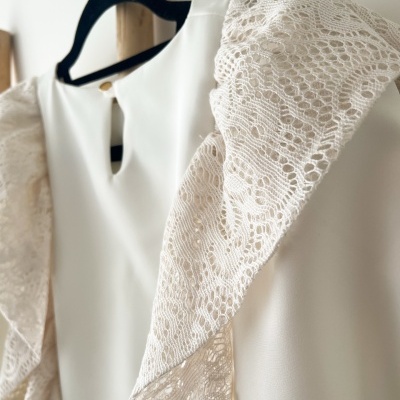 Vestido branco com mangas de renda floral em cabide preto