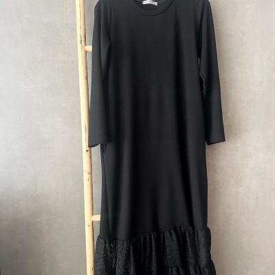 Vestido preto com mangas compridas e barra em renda preta pendurado