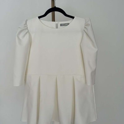 Vestido branco de manga comprida com saia rodada num cabide preto