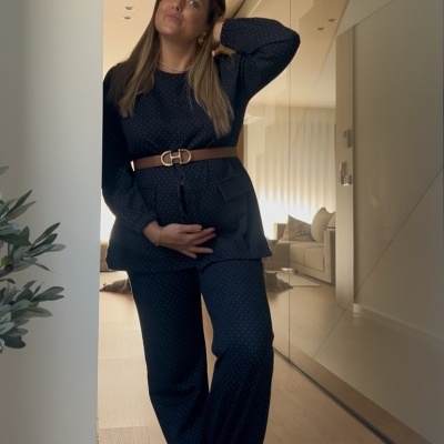 Conjunto de pijama azul escuro com pontos brancos usado por mulher num interior moderno.