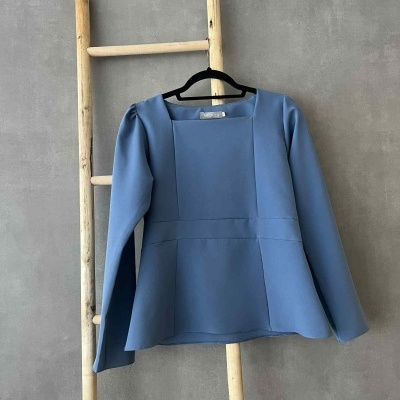 Blusa azul de manga longa numa escada de madeira