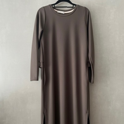 Vestido castanho de manga comprida pendurado num cabide preto